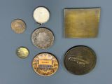 several different coins are displayed on a blue surface