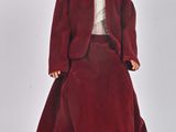 une poupée vêtue d'une robe rouge et d'un chapeau
