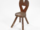 a small wooden chair with a heart on the back