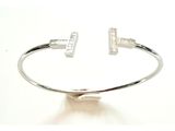 un gros plan d'un bracelet en argent sur lequel figure une lettre