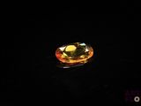 a close up of a yellow diamond on a black surface