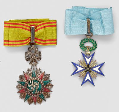 three medals are displayed on a white surface with a blue ribbon