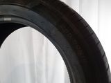 a close up of a tire on a white surface with a curtain in the background