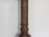 a tall wooden column with a carved design on top of it