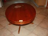 a wooden table with a glass top on a tile floor