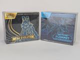 deux boîtes de cartes à collectionner Pokémon posées sur une surface blanche
