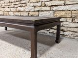 a coffee table that is sitting in front of a stone wall
