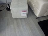un pouf blanc posé dans un salon, à côté d'un tapis noir