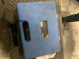 a blue case sitting on the floor next to a pair of scissors
