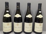 quatre bouteilles de vin sont alignées sur une table