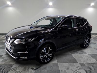 un SUV Nissan noir garé sur un sol à damier dans un garage