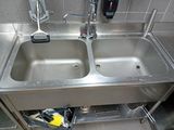 a stainless steel sink with two faucets on the side of it