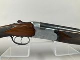 a shotgun with a wooden barrel and a metal handle on a clear stand