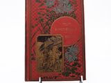 an old red book with a picture of a man and a woman on it