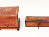pair of antique wooden boxes on wheels on a white surface