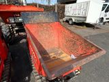 a red dump truck parked next to a white truck