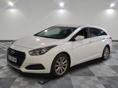 une voiture blanche est garée dans une pièce au sol à carreaux