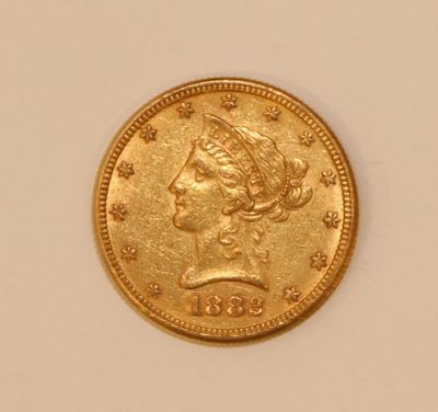 a close up of a gold coin on a white surface