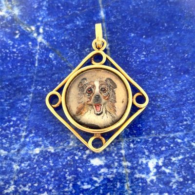 un gros plan sur l'image d'un chien figurant sur un pendentif