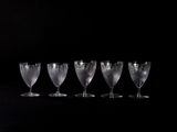 quatre verres à vin vides sont alignés sur une surface noire