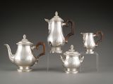 four pieces of silver tea and coffee set on clear acrylic bases