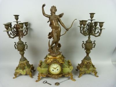 trois horloges différentes et une statue posées sur la table