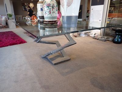 une table en verre sur laquelle se trouve un vase