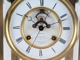 a gold clock with roman numerals on the face