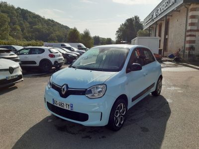 une petite voiture blanche garée devant un bâtiment