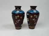 une paire de vases posés sur une surface blanche, sur fond blanc