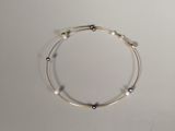 bracelet en perles argentées et noires sur un fond blanc
