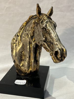 statue of a golden horse head on a black base