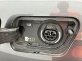 a close up of a car ' s fuel pump with a person standing in the background