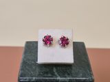 a pair of pink sapphire earrings sitting on top of a marble block