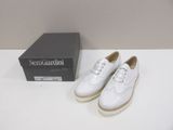 pair of white leather shoes with white laces on a white table