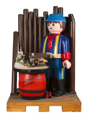 une figurine représentant un homme debout à côté d'un tonneau