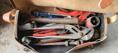 une boîte remplie d'outils posés sur le sol
