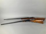 a rifle with two guns on a white background