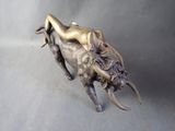 bronze statue of a woman laying on a bull on a gray background