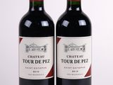 two bottles of red wine sitting next to each other on a white surface