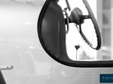 a close up of a car ' s side mirror with a steering wheel
