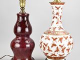 pair of chinese vases on stands with a lamp on top of them