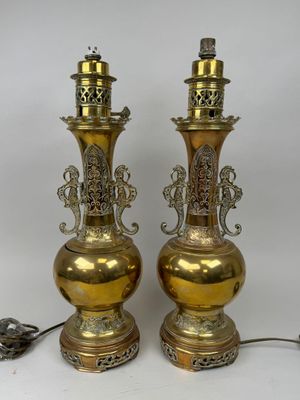 une paire de vases anciens en laiton, ornés chacun de motifs élaborés