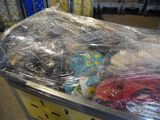 a pile of stuffed animals wrapped in plastic on a cart