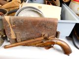 a gun and a case sitting on a table with other items