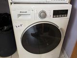 une machine à laver et un sèche-linge blancs, empilés l'un sur l'autre dans une pièce