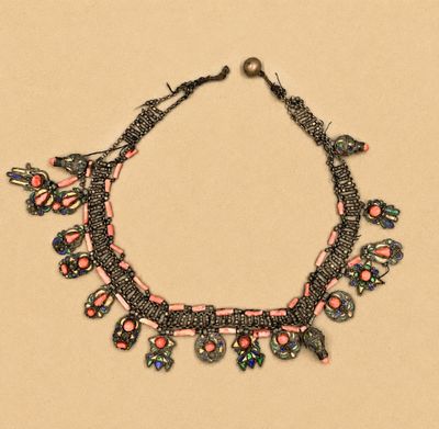 un gros plan d'un collier posé sur une surface beige