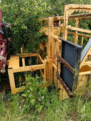 un tracteur qui est garé dans l'herbe, près d'une clôture