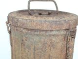 an old metal container with a handle on a white surface