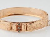 a close up of a gold bracelet on a chain